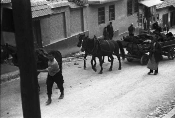 Viaggio in Jugoslavia. Sarajevo: un carro adibito al trasporto merci viene trainato verso la cima di un vicolo in salita