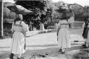 Viaggio in Jugoslavia. Sestine: lavandaie (riprese da tergo) che tornano dal fiume con i panni lavati portandoli in testa in una conca di legno
