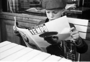 Viaggio in Jugoslavia. Zagabria: giovane recluta ustascia seduta al tavolino di un bar mentre legge il giornale "Tempo". Indossa giacchetta con svastica nazista appuntata sul bavero e fascia al braccio con la scritta "ustascia"