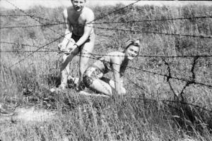Viaggio in Jugoslavia. Zagabria: ritratto di coppia, bagnati scvalcano il filo spinato che protegge le rive del fiume Sava