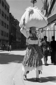 Viaggio in Jugoslavia. Zagabria: donna croata con carico sulla testa. Indossa abiti tradizionali in occasione del lunedì di Pentecoste