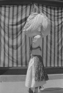 Viaggio in Jugoslavia. Zagabria: donna croata con carico sulla testa. Indossa abiti tradizionali in occasione del lunedì di Pentecoste