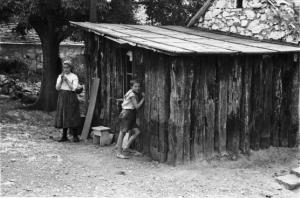 Viaggio in Jugoslavia. Perkovic: coppia di fanciulli davanti a un magazzino di legno all'interno dell'aia