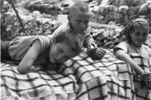 Viaggio in Jugoslavia. Perkovic: fanciulli di famiglia contadina posano nei pressi di una balla di fieno, coperta da una tovaglia a quadri