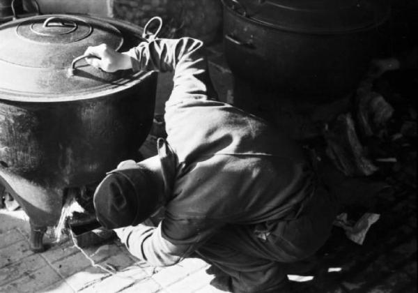 Internamento in Svizzera. Horriwil - Scene di vita quotidiana all'interno del campo, un soldato attizza il fuoco sotto una delle cucine
