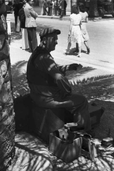 Viaggio in Jugoslavia. Dubrovnik (Ragusa): scene di vita quotidiana - ambulante seduto lungo una strada della cittadina