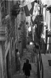 Viaggio in Jugoslavia. Dubrovnik (Ragusa): scorcio di un vicolo nel centro urbano con coppia di passanti