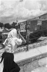 Viaggio in Jugoslavia. Mostar: scorcio dal Ponte Vecchio - donna che lo attraversa. Sullo sfondo è visibile il paese