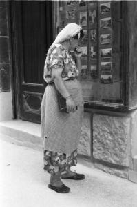 Viaggio in Jugoslavia. Mostar: scene di vita quotidiana - una donna osserva cartoline esposte in una vetrina