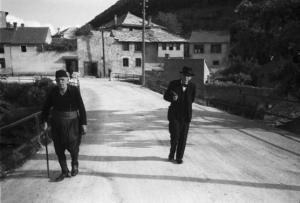 Viaggio in Jugoslavia. Mostar: coppia di uomini anziani percorre una strada lasciandosi il paese alle spalle