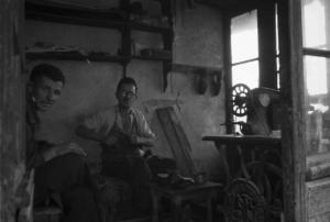 Viaggio in Jugoslavia. Mostar: scene di vita quotidiana - calzolaio al lavoro nel suo negozio con un amico
