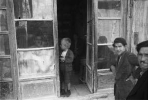 Viaggio in Jugoslavia. Mostar: scene di vita quotidiana - bambino sulla soglia di un locale