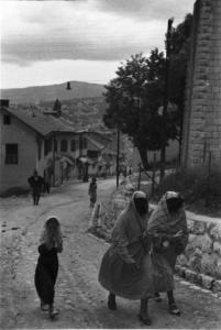 Viaggio in Jugoslavia. Sarajevo: coppia di donne bosniache in costume locale passeggiano accompagnate da una fanciulla verso una stada in salita