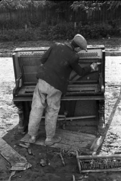 Campagna di Russia. Balti - uomo osserva un pianoforte rotto e abbandonato per strada