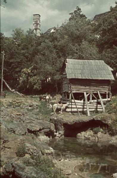 Viaggio in Jugoslavia. Yaitze: scorcio di un magazzino in legno nei pressi di un fiumiciattolo