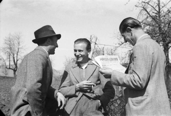 Internamento in Svizzera. Campo di Horriwil, gruppo di uomini che conversano tra loro. Uno legge il giornale "Popolo e Libertà"
