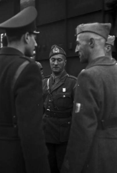 Italia Seconda Guerra Mondiale. Caserma militare di Riva del Garda - partenza della legione croata: tre ufficiali dell'esercito croato discutono in prossimità di un treno