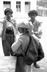 Viaggio in Jugoslavia. Yaitze: coppia di mercanti bosniaci in costume locale posa nella zona del mercato