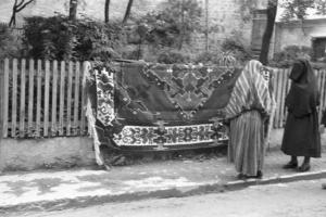 Viaggio in Jugoslavia. Yaitze: una coppia di anziane donne bosniache osserva alcuni tappeti appoggiati sopra una staccionata, a mergine di una strada