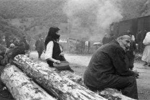 Viaggio in Jugoslavia. Yaitze - stazione ferroviaria: una coppia di anziani bosniaci in abito locale attende la partenza del treno seduta sopra due tronchi di legno