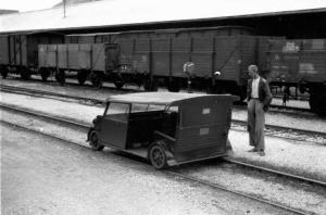 Viaggio in Jugoslavia. Banja Luka: stazione ferroviaria. Un uomo in piedi davanti a un piccolo veicolo adibito a trasporto merci su rotaia