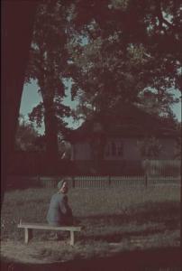 Viaggio in Jugoslavia. Zagabria: una signora sospresa di spalle seduta sopra una panchina all'interno di un giardino, nei pressi di una altalena, mentre osserva alcuni bambini giocare