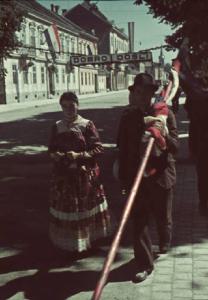 Viaggio in Jugoslavia. Zagabria: una coppia di abitanti in giro per le vie della città - l'uomo porta una bandiera sulle spalle