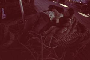 Viaggio in Jugoslavia. Da Spalato a Ragusa: un uomo dorme appoggiato sulla fune dell'ancora durante il tragitto