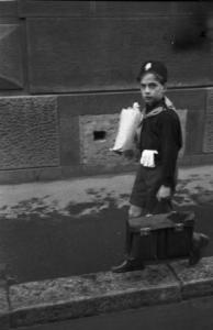 Italia Seconda Guerra Mondiale. Milano - raccolta della lana durante il regime fascista: giovane Balilla sorpreso con la busta per il trasporto della lana in una via del quartiere durante il tragitto che lo porta a scuola