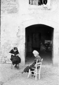Roma - isola Tiberina. Scorcio dell'esterno di una abitazione con una coppia di anziani seduti su due sedie