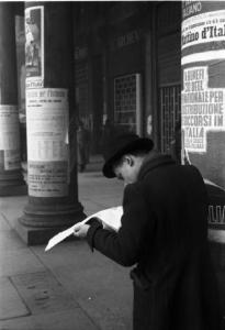 Italia Dopoguerra. Milano - piazza Vetra - Un uomo legge il giornale camminando