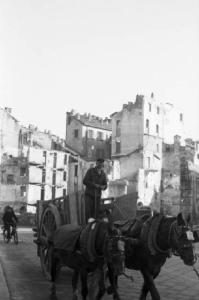 Italia Dopoguerra. Milano - piazza Vetra - Scorcio tra gli edifici sventrati dalle bombe - In primo piano un carro trainato da cavalli