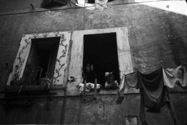 Italia Dopoguerra. Roma - Quartiere Trastevere - bambina affacciata alla finestra - panni stesi lungo la facciata