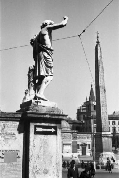 Roma. Scorcio di Piazza del Popolo. In primo piano statua che orna l'esedra, sullo sfondo l'obelisco Flaminio
