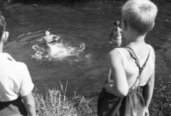 Milano - Naviglio - gruppo di bambini nuota nell'acqua del canale