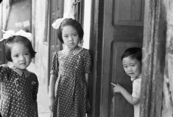 Italia Dopoguerra. Milano - Quartiere cinese - alcuni bambini sulla soglia della loro abitazione