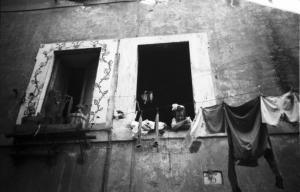 Italia Dopoguerra. Roma - Quartiere Trastevere - bambina affacciata alla finestra - panni stesi lungo la facciata