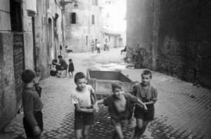 Italia Dopoguerra. Roma - Quartiere Trastevere - vita di strada - gruppo di bambini gioca con un carretto