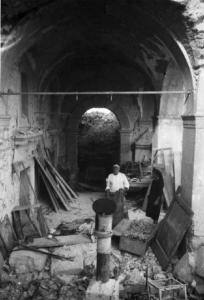 Italia Dopoguerra. Montecassino - Abbazia - Scorcio di un porticato semidistrutto dai bombardamenti  con un uomo che si aggira tra le macerie