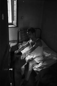 Italia Dopoguerra. Milano - Albergo popolare - Camera da letto, interno - Ospite in mutande e canottiera