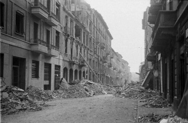 Italia Seconda Guerra Mondiale. Milano. La città dopo il bombardamento del 12 agosto 1943, una via deserta con edifici danneggiati e macerie