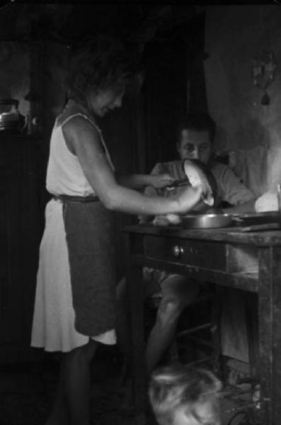 Italia Dopoguerra. Milano - Periferia - Baraccopoli - Norma Barbieri prepara il pranzo alla propria famiglia