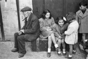 Roma. Pincio. Gruppo di bambini siede su una vecchia cassa insieme a un uomo anziano al concerto domenicale