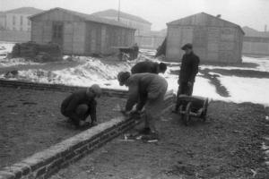 Italia Dopoguerra. Milano - Quartiere Baggio - Gruppo di operai lavorano alla edificazione di un muro perimetrale di un edificio