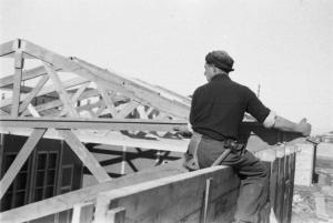 Italia Dopoguerra. Milano - Quartiere Baggio - Un operaio costruisce il tetto di un edificio abitativo prefabbricato