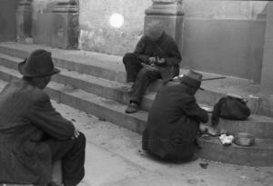 Italia Dopoguerra. Milano - Mendicante seduto per strada controlla il contenuto del suo cappello