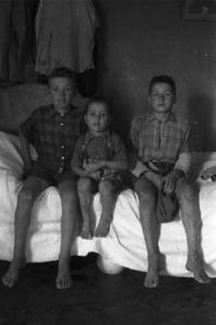 Italia Dopoguerra. Marzabotto - Ritratto di gruppo, tre ragazzini seduti su un letto