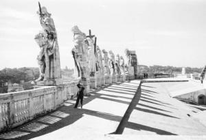 Roma. Piazza S. Pietro. Uno degli amici di Patellani scatta fotografie tra le statue del coronamento alla sommità del colonnato del Bernini
