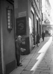 Italia Dopoguerra. Genova - Uomo anziano chiede l'elemosina all'angolo di Vico Stella