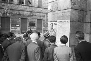 Italia Dopoguerra. Genova - Gruppo di uomini legge i manifesti del P -C -I - e dell'A -G -D -G -A -D -U - affissi su un muro
